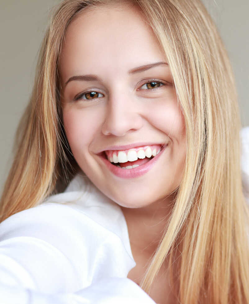 woman with long blonde hair smiling at the camera